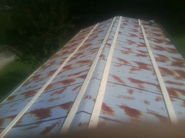 Rusted metal roof panels with new wood purlins before replacement — Storm Damage Roof Repair in Dunn Loring by Roofing Brothers