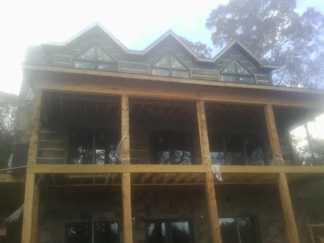 Dormers and porch framing on a large log home under construction — Roof Coating work by our crew in Dunn Loring