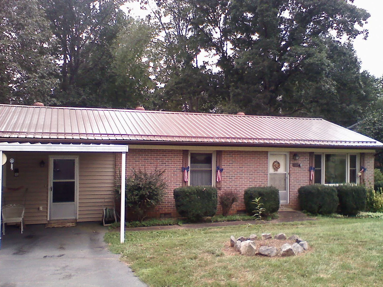 Bronze metal roof and carport on a brick ranch home — Roof Repair work by our crew in Dunn Loring