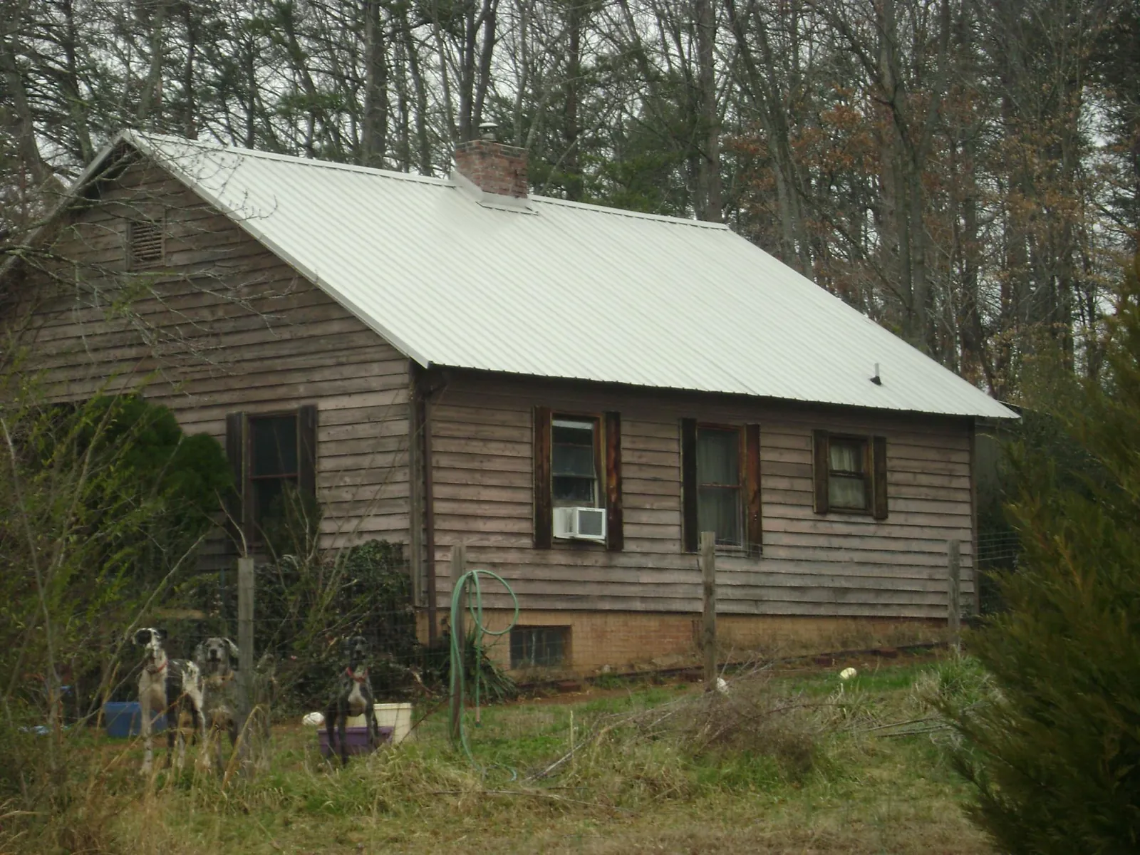 White metal roof on an old wood sided farmhouse, from a Metal Roof Installation job in Dunn Loring